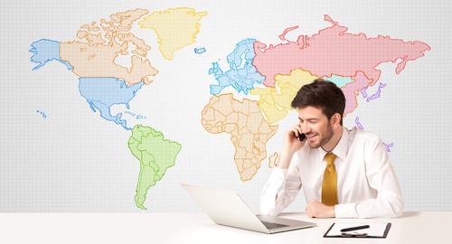 Un homme téléphone à son bureau dans son dos une carte murale